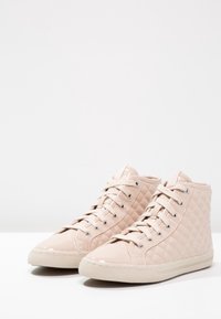 Höga sneakers i ljusrosa kviltad lackläder med rund tå, snörning fram och platta gummisålar.