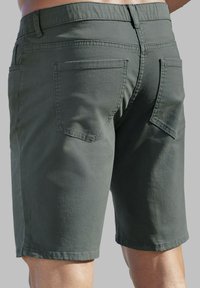 Dunkelgrüne Shorts aus Baumwolle, gerade geschnitten, mit zwei Gesäßtaschen und minimalen Nähten.