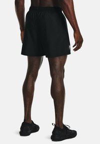 Svarta träningsshorts med elastiskt midjeband, lättviktsmaterial och en liten logotyp på nedre vänstra sidan. Bärs med svarta träningsskor.