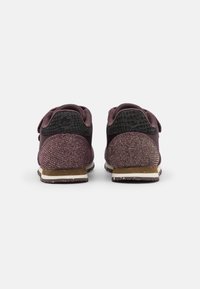 Scarpe da corsa viola con tessuto testurizzato, retro liscio e un accento nero a contrasto. Presentano una suola imbottita e dettagli a motivo.