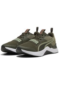 Žalios tinklinės sportinės bateliai su balta padu, turintys ryškų PUMA logotipą, tekstūriniais akcentais ir kontrastingomis detalėmis. Žemas profilio dizainas su užtrauktukais.