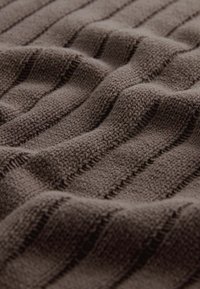 Tissu en tricot marron foncé avec des rayures horizontales texturées. Le tissu semble doux, avec un motif légèrement en relief et un aspect douillet.