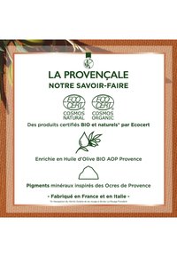 Étiquette avec texte vert sur fond blanc, comportant les logos EcoCert. Bordure texturée marron, graphique en olive et détails visuels en pigments minéraux.