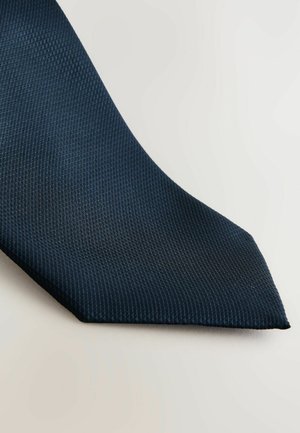 Navy blue tie with a textured weave, featuring a pointed tip and a subtle pattern, made of fabric with a smooth finish.
