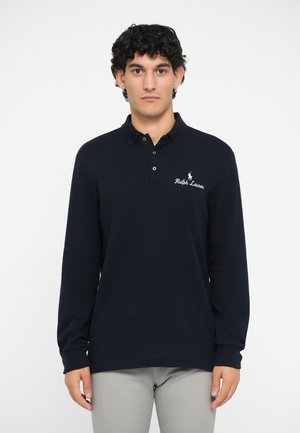 Camisa polo de manga larga en color navy, hecha de algodón, con cuello y tres botones en la parte delantera, y logo blanco bordado en el lado izquierdo del pecho.