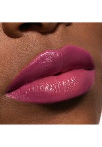 Nærbillede af læberne med en glitrende pink læbestift i forskellige nuancer, glat tekstur og en naturlig hudfarve baggrund.