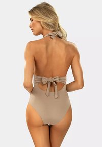 Beżowy jednoczęściowy strój kąpielowy z wycięciami na plecach, marszczonym materiałem i detalem w postaci kokardy. Gładka tekstura, średnio-wysoki krój nogawki.
