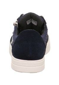 Granatowe sneakersy z teksturowaną tkaniną na cholewce i gładkimi zamszowymi akcentami. Biała gumowa podeszwa i widoczne miękkie szare wykończenie wnętrza.