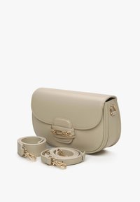 Beżowa torebka na ramię z sztucznej skóry o zaokrąglonych krawędziach, z magnetycznym zapięciem, złotymi akcentami i dwoma regulowanymi paskami.
