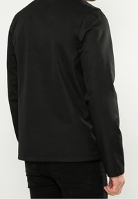 Czarna, długosleeve kurtka o gładkiej fakturze i okrągłym dekolcie, charakteryzująca się prostym fasonem i subtelnymi detalami przeszyć na plecach.