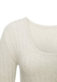 Helles beige, geripptes Oberteil mit weiter Rundhalsausschnitt und subtiler Textur. Das Material wirkt weich und leicht dehnbar.