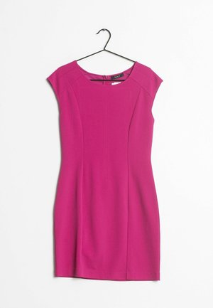 Zářivě růžové šaty bez rukávů s kulatým výstřihem visící na černém ramínku na bílém pozadí.