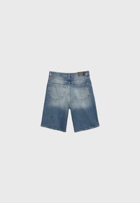 Short en denim avec deux poches arrière, détail délavé, passants de ceinture et une petite étiquette noire de la marque sur la ceinture.