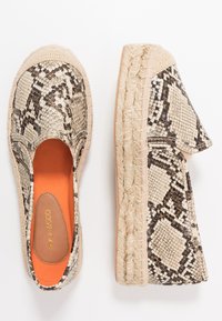 Espadrille slip-on shoes with a beige and black snake print upper, textured fabric, orange insole, and jute-wrapped outsole.