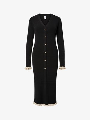 Lang svart ribbestrikket cardigan med V-hals, gullfargede hjerteformede knapper og kremfargede volangdetaljer på mansjettene og nederkanten.