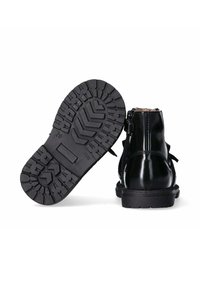 Stivali alla caviglia in pelle verniciata nera con suola in gomma testurizzata, zip laterale e dettaglio a fiocco decorativo sul retro.