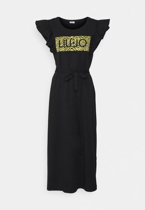 Robe midi noire sans manches avec des épaules à volants, une ceinture en tissu à la taille et un panneau à imprimé animalier jaune avec texte sur la poitrine.
