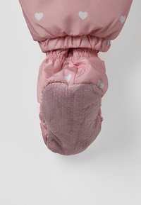 Roze kinderwant met witte hartpatronen en een gestructureerd, gripverbeterd palmgebied tegen een effen achtergrond.