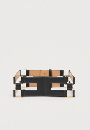 Black leather belt with double geometric cutout design and gold metal hardware, shown flat on a light background.