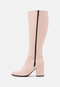 Knöchelhohe, pinke Kunstlederstiefel mit Blockabsatz und einem schwarzen Seitenreißverschluss. Glatte Textur, spitze Zehenform und ein enganliegendes Schaft.