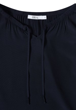 Marineblå bluse med V-hals, elastisk samling ved halsudskæringen og justerbare snore til pasform. Lavet af blødt, let stof.