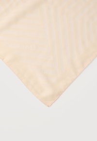 Coin de tissu beige en soie avec un motif subtil de rayures géométriques et un logo "BOSS" discret en relief sur un fond blanc.