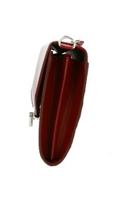Portafoglio rosso in pelle con un design slim, caratterizzato da un anello in metallo argentato nella parte superiore e una superficie liscia e lucida. La vista laterale mostra due scomparti.