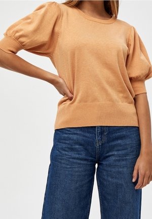 Lys orange strikket sweater med korte pufærmer og ribbet kant, parret med blå brede bukser. Blød tekstur og afslappet design.