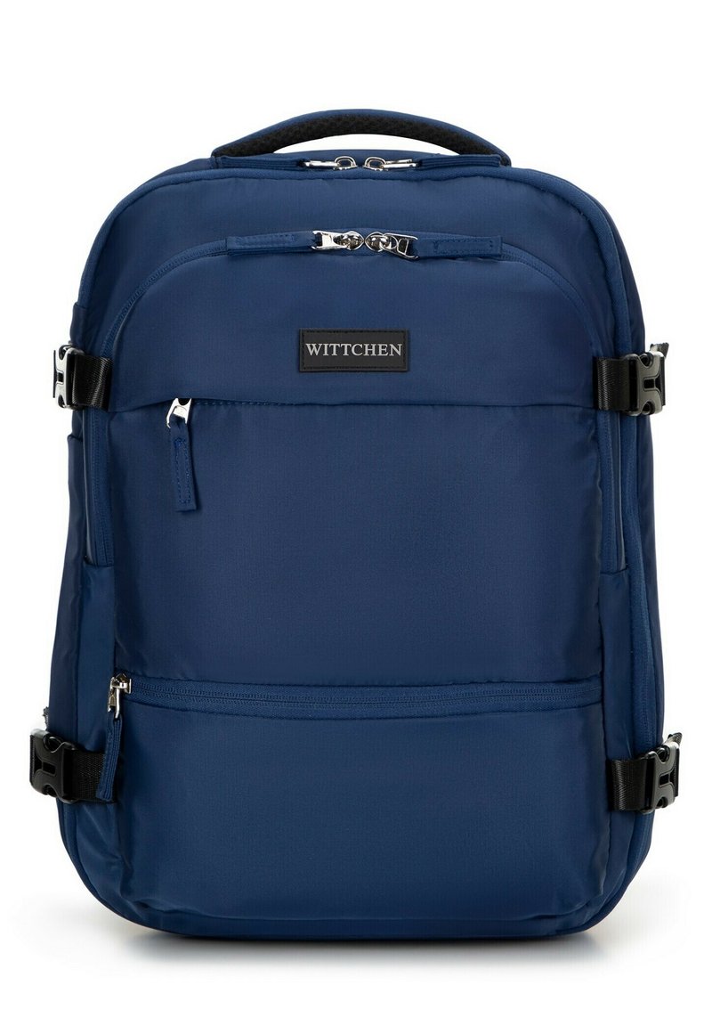 Námorně modrý látkový batoh s několika zipovými kapsami, nastavitelné popruhy a odolnou horní rukojetí. Obsahuje černou aplikaci značky.