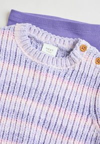 Pull en laine texturé rose et lavande à rayures avec un design à côtes et des boutons en bois. Inclut une ceinture en côtes violette unie en dessous.