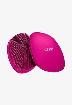 Brosse de nettoyage visage en silicone ronde de couleur rose vif avec des poils doux, montrant l'avant et l'arrière, étiquetée "GESKE" sur le côté lisse.