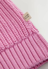 Rózsaszín kötött sapka, különböző textúrákkal: alul bordázott, fent sima. Egy kis címkén az áll, hogy "Little Bird". Puha, rugalmas anyag.