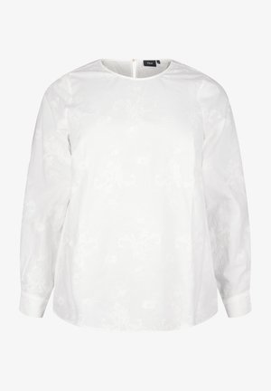 Balta palaidinė su ilgomis rankovėmis, apvaliu kaklu ir subtilia gėlių tekstūra. Įrengta nugaroje esanti maža skylutė su užtrauktuku. Lygus medvilninis audinys.