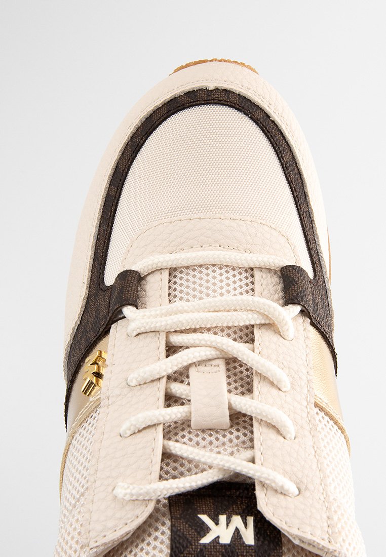 Baskets beiges avec tige en maille, accents en cuir marron, accessoires dorés et lacets texturés. Présente une pointe arrondie et une semelle rembourrée.