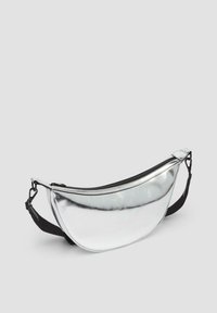 Silberne metallische Hüfttasche mit geschwungenem Design, Reißverschluss und einstellbarem schwarzen Gurt. Glatte Textur mit glänzender Oberfläche.