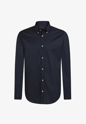 Camisa azul marino de botonadura hecha de un suave tejido de algodón. Presenta un collar clásico, mangas largas y un sutil bordado del logo en el pecho.