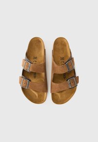 Pair of brown suede sandals with two adjustable buckle straps, tan contoured footbeds, and size markings inside.