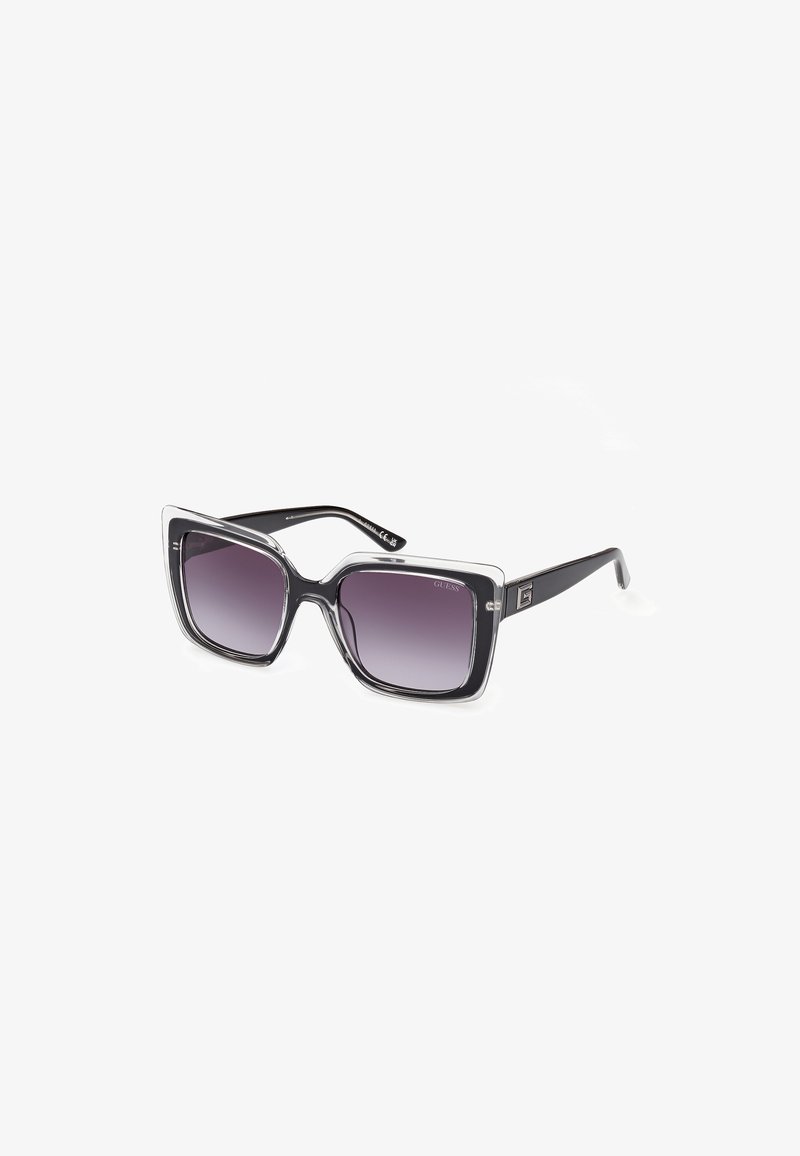 Ochelari de soare supradimensionați, negri și transparenți, cu o formă pătrată. Lentile gradient violet și textură cu model pe rame. Prezintă un detaliu cu logo.