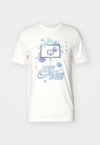 Camiseta blanca de algodón con un gráfico de baloncesto, palmeras y el texto "JUST DO IT" en azul, con balones de baloncesto coloridos como acentos.