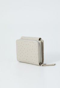 Beige wallet made of textured material, featuring a zip closure and a pattern of small, raised pink dots on the surface.