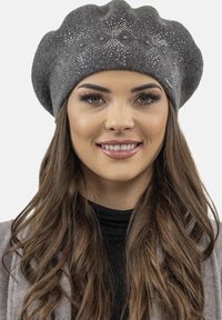 Béret gris en feutre avec un design texturé et froncé, orné de strass sur le devant. Tissu doux et forme arrondie.