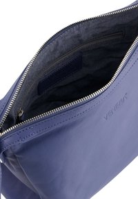 Dunkelblaue Lederhandtasche mit Reißverschluss und glatter Textur. Das Innere ist mit einem dunklen Stoff gefüttert und verfügt über eine kleine Reißverschlusstasche. VENEZIA-Branding sichtbar.