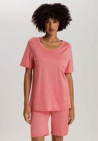 Roze katoenen loungewear set bestaande uit een top met korte mouwen en een ronde hals, voorzien van een borstzak, gecombineerd met bijpassende shorts.