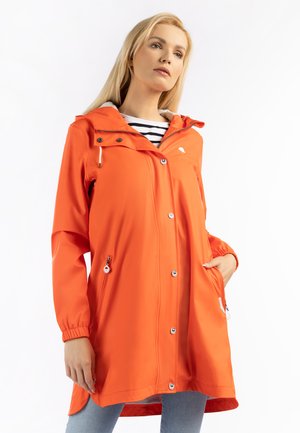 Orange vandtæt regnjakke med hætte, to lynlåslommer, trykknapper foran og elastiske manchetter. Stribet skjorte nedenunder.