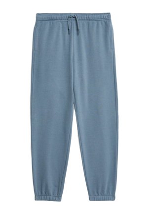 Lyseblå hættetrøje med en frontlomme og matchende sweatpants. Kombineret med røde sneakers og en sort crossbody taske med lynlåse.