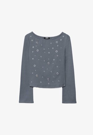 Top a maniche lunghe grigio corto con occhielli in metallo argentato di varie dimensioni sparsi sul davanti.