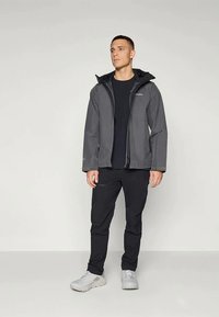 Gray waterproof jacket with a hood, paired with a black t-shirt and black pants. Features a front zipper and adjustable cuffs.