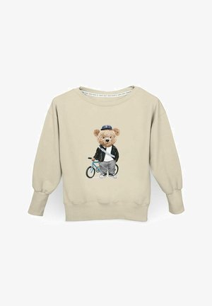 Beżowy sweter z grafiką niedźwiedzia w okularach, kurtce i czapce, stojącego obok niebieskiego roweru. Prążkowane mankiety i dół.