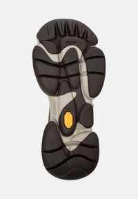 Suola Vibram in gomma nera e grigia con texture, caratterizzata da motivi di battistrada distintivi e un logo giallo. Design ergonomico per aderenza e durata.