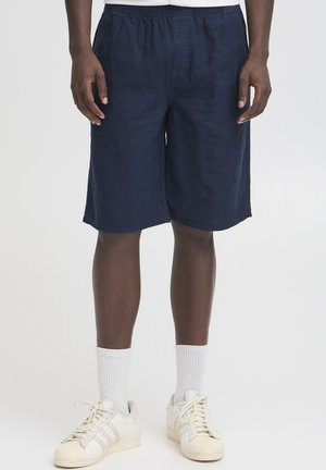 Marineblaue, knielange Shorts aus leichtem Material mit elastischem Bund, die eine glatte Textur und saubere Kanten aufweisen.